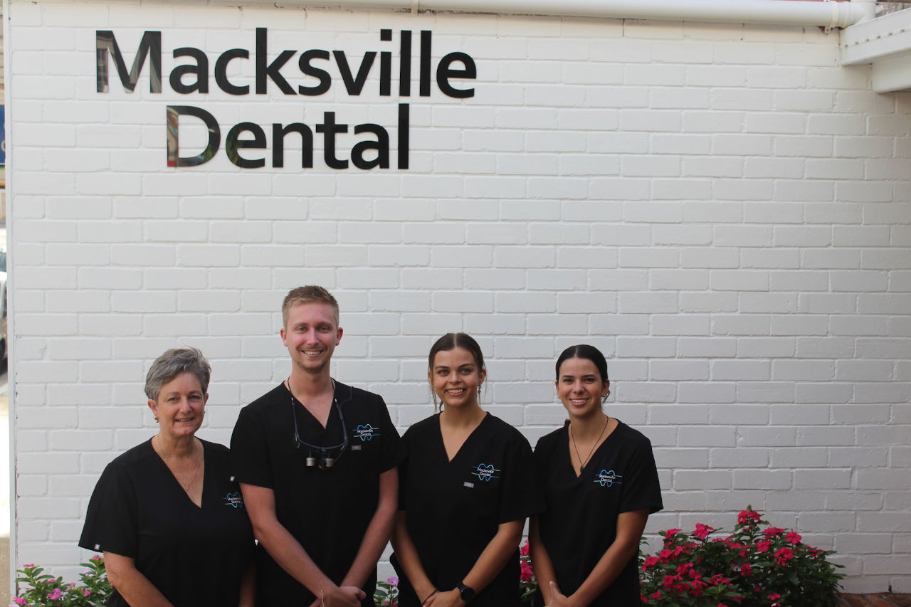 Dr Joshua Fitzgerald standing in front of his dental surgery with the team in Macksville, NSW